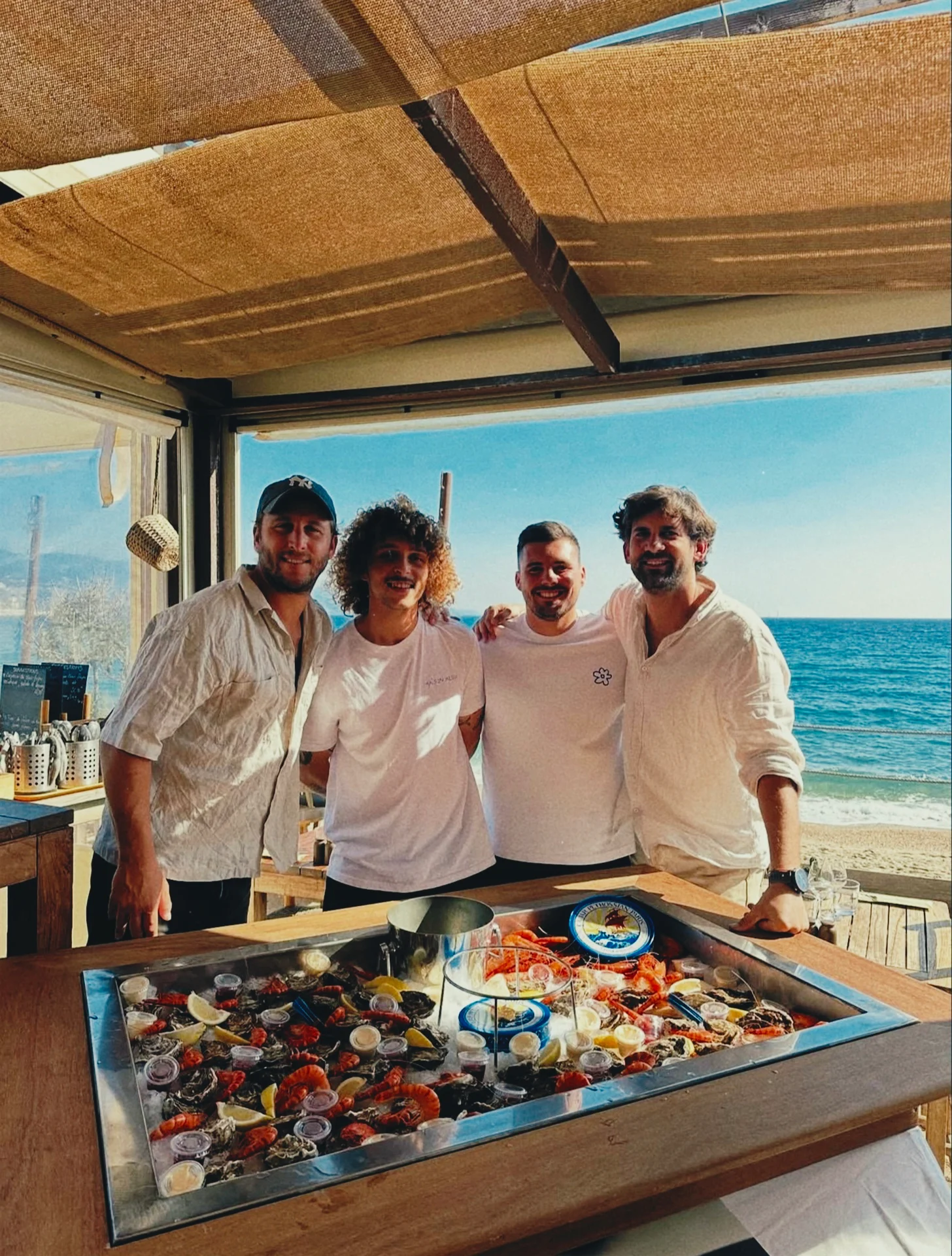 L'équipe du Petit Écailler posant devant le comptoir au bord de mer